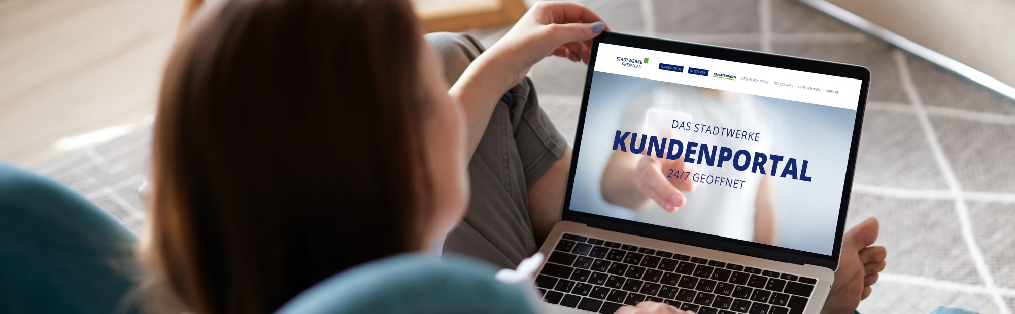 Eine Frau sitzt mit Ihrem Laptop auf der Couch und auf dem Display ist das Stadtwerke Kundenportal zu sehen